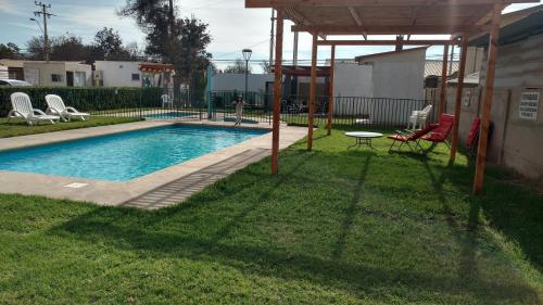 a swimming pool in a yard with a table and chairs at Arriendo Departamento Diario en Copiapo in Copiapó