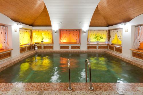 a large indoor pool in a room with windows at Hotel Semigorie in Shaldovo