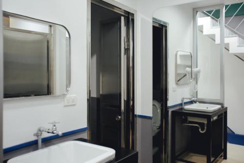 a bathroom with a sink and a mirror at Tales Khaosan (Cafe & Hostel) in Bangkok