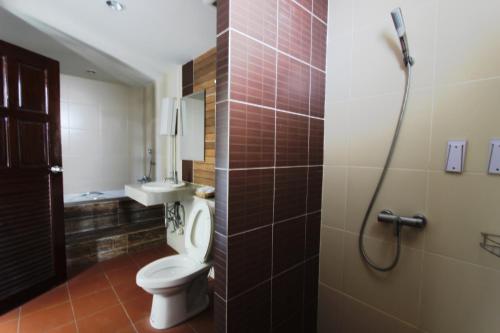 a bathroom with a toilet and a sink and a shower at Baan Pordeedin in Chiang Rai