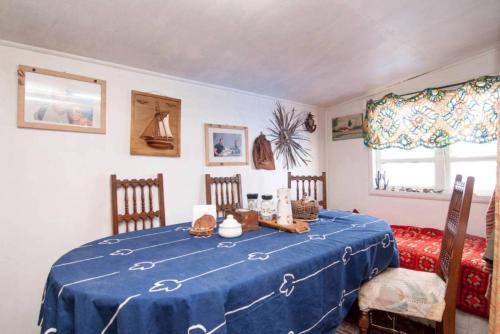 Una habitación con una mesa azul con sillas y una cama en Palafitos Emilio y Ester, en Castro