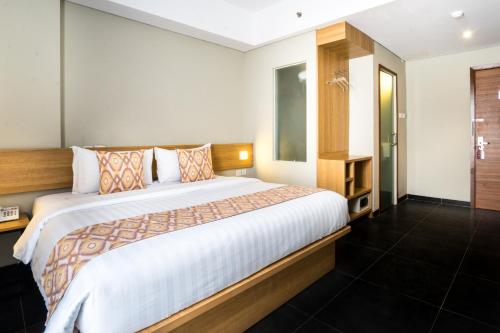 a bedroom with a large bed in a room at Maple Hotel Grogol in Jakarta