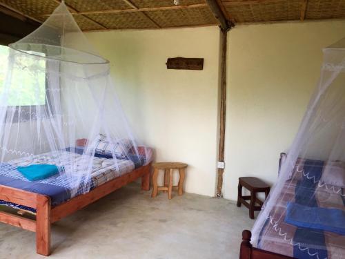 a bedroom with a bed with mosquito nets in it at Karungi Camp in Rubuguli