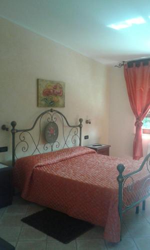 a bedroom with a bed with a red bedspread at B & B OASI in Rosciano
