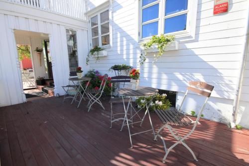a group of chairs and tables on the porch of a house at Opsahl Gjestegaard in Bodø