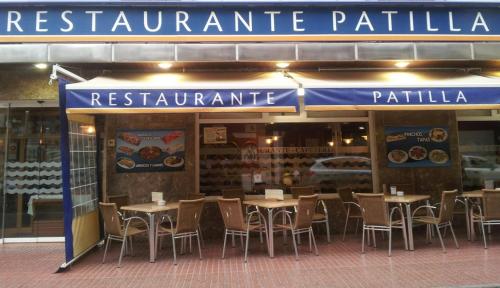 un restaurante con mesas y sillas frente a él en Hotel Patilla, en Santa Pola