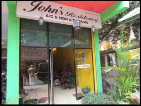 a building with a sign on the front of it at Johns Residency in Cochin