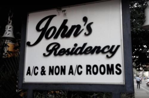 a sign that reads joints redundancy ape and non ac rooms at Johns Residency in Cochin