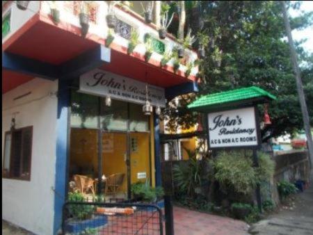 a restaurant with a green awning and a store at Johns Residency in Cochin