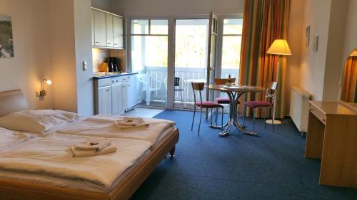 オストゼーバート・ゼリンにあるStudio 23, Residenz Seeblickのベッド、キッチン、テーブルが備わるホテルルームです。