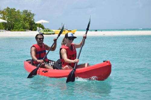 a man and woman in a red kayak in the water at Araamu Hotels Maldives at Dhiffushi in Dhiffushi