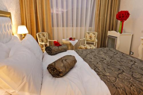 a hotel room with a bed with pillows on it at Hotel Roman by Dumbrava Business Resort in Roman