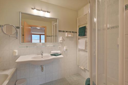 a white bathroom with a sink and a mirror at Hotel Andrea in Mayrhofen