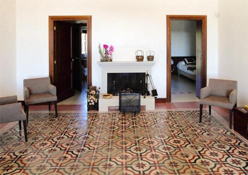 a living room with a fireplace and two chairs at Vecchia Dimora Resort in Centuripe