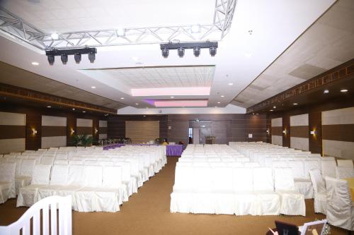 a large banquet hall with white tables and chairs at KGA Elite Continental Hotel in Thiruvalla