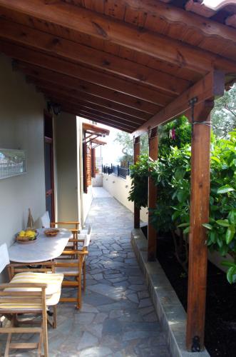 a patio with a table and chairs under a wooden pergola at Amaryllis Holiday Home in Agios Spiridon Fokidas