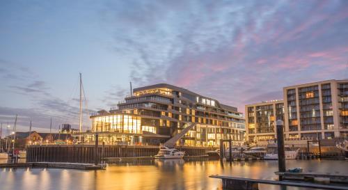 un bâtiment éclairé en face d'un port de plaisance dans l'établissement Harbour Hotel & Spa Southampton, à Southampton