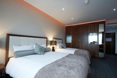 a hotel room with two beds and a mirror at Rochestown Park Hotel & Leisure Centre in Cork
