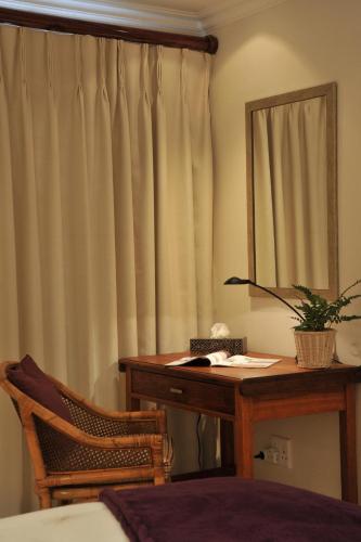 a bedroom with a table and a mirror and a desk at Claires of Sandton Luxury Guest House in Johannesburg