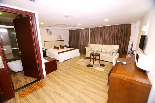 a hotel room with a bed and a couch at KGA Elite Continental Hotel in Thiruvalla