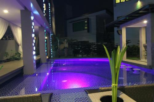 a swimming pool at night with purple lights at Eloisa Royal Suites in Mactan