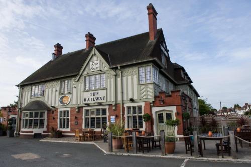 a building with tables and chairs in front of it at The Railway by Innkeeper's Collection in Hornchurch