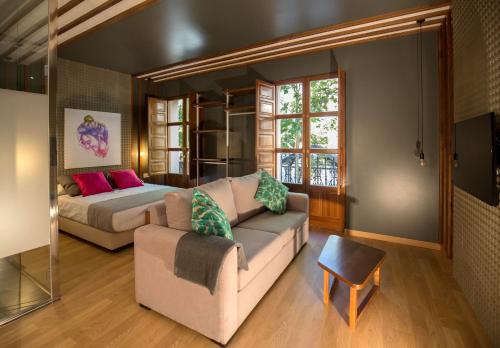 a living room with a couch and a bed at Apartamentos Ele San Justo Plaza in Salamanca
