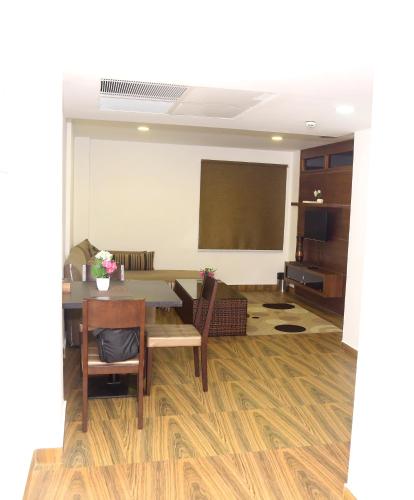 a meeting room with a table and chairs and a screen at KGA Elite Continental Hotel in Thiruvalla