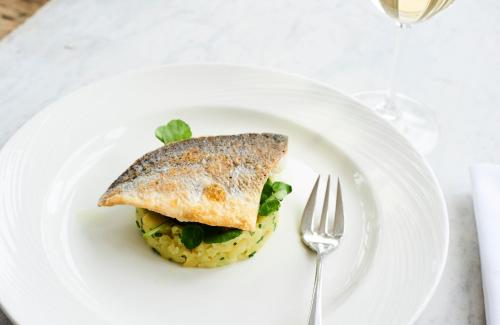 a white plate with a sandwich on top of rice at Harbour Hotel & Spa Sidmouth in Sidmouth