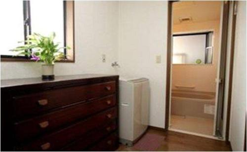 uma casa de banho com uma cómoda e um espelho grande em Youyousanso Traditional A em Tsu