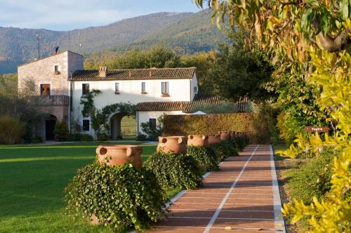 a garden with a brick walkway in front of a house at La Tenuta Dei Ciclamini in Avigliano
