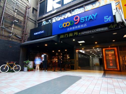 two people standing in front of a building at Good 9 Stay Inn in Taipei