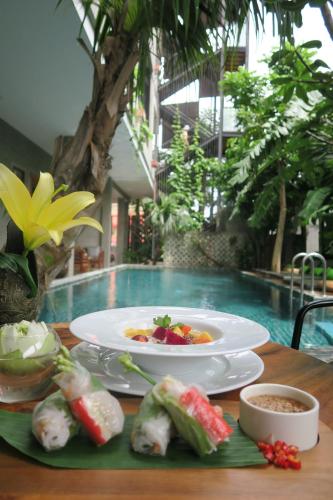 a table with a plate of food and a bowl of food at Sarina Boutique Hotel in Phnom Penh