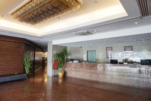 a lobby of a hotel with a reception desk at Kingwood Hotel Kuching in Kuching