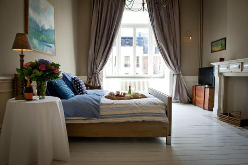 ein Schlafzimmer mit einem Bett und einem Tisch mit Blumen darauf in der Unterkunft B&B Le Seize in Brüssel