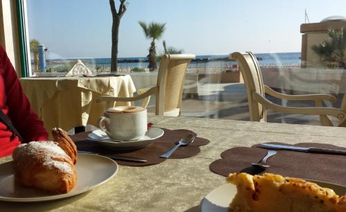 Una mesa con un plato de comida y una taza de café. en Hotel Augusta, en Bellaria-Igea Marina