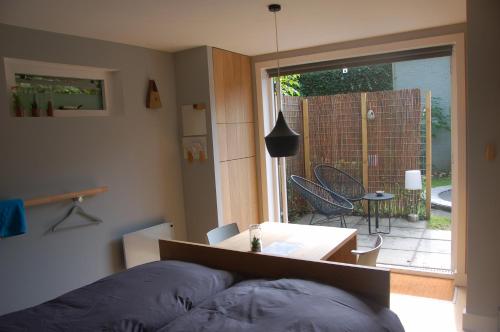 een kamer met een bed, een tafel en een raam bij B&B EINDHOVENnearby in Waalre