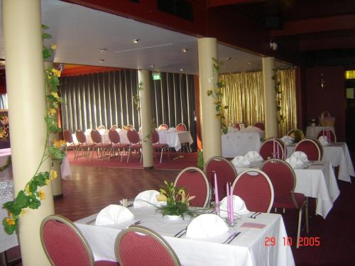 un salón de banquetes con mesas y sillas blancas en Hotel Kiteenhovi, en Kitee