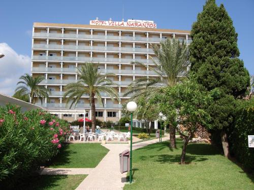 un hotel con palmeras frente a un edificio en Hotel Villa Naranjos en Jávea