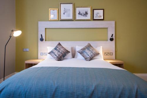 a bedroom with a large bed with two pillows at The Calverley Arms by Innkeeper's Collection in Pudsey