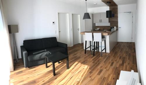 a living room with a black couch and a table at Appartement Tirolina in Innsbruck