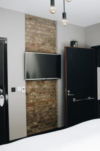 a room with a television and a brick wall at Camden Enterprise Hotel in London