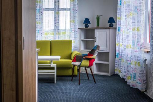 a living room with a chair and a couch at Kopeček - Penzion in Česká Lípa