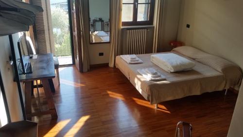 a small bedroom with a bed and a wooden floor at B&B La Bergamina 26 in Pero