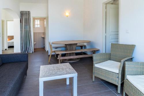a living room with a couch and a table and chairs at Domaine de Pianiccia in Sari Solenzara