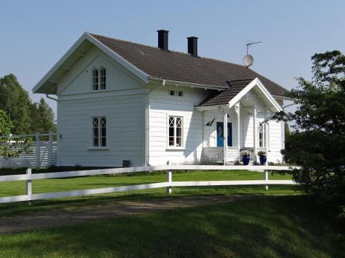 una casa bianca con una recinzione bianca davanti di Isaberg Golfklubb a Hestra
