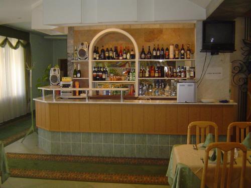 a bar with a counter with bottles of alcohol at Zhibek Zholy Hotel in Astana