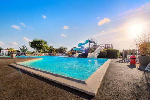 a large swimming pool with a water slide at Camping RCN La Ferme du Latois in Coëx