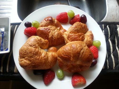 a plate of pastries and fruit on a table at Buenos Aires Guest House in Bexhill