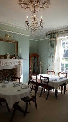 a dining room with two tables and a chandelier at Cannaway House B&B in Macroom